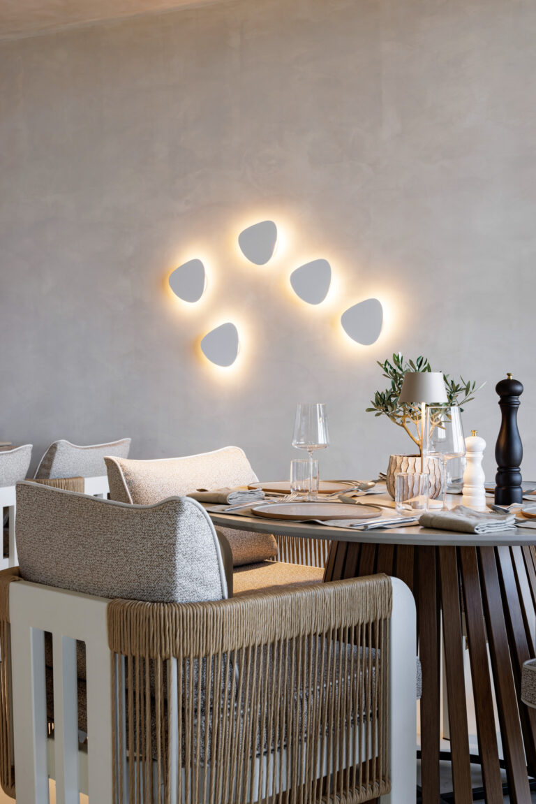 Dining area at Maximus Mykonos with sculptural wall lights