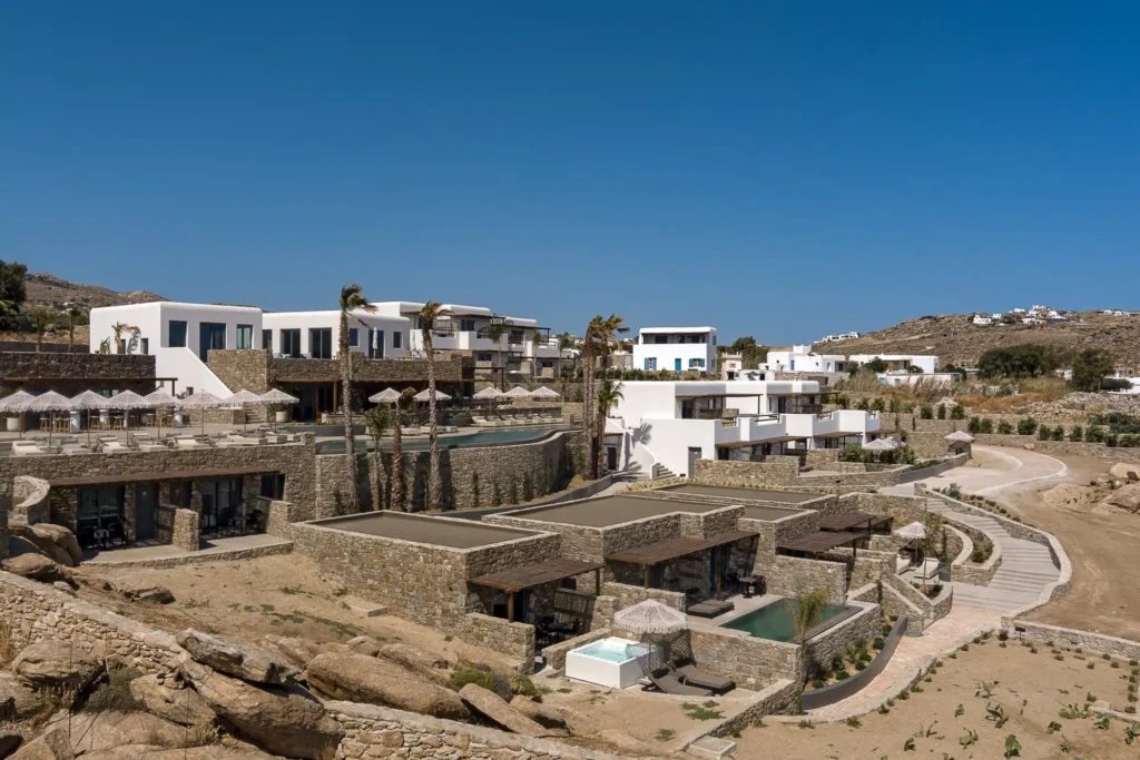 Τα κτίρια και η πισίνα του Maximus Mykonos 5* κάτω από καθαρό ουρανό